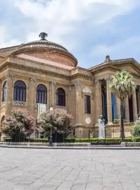 ancient building of opera house located on well groomed square against blue sky