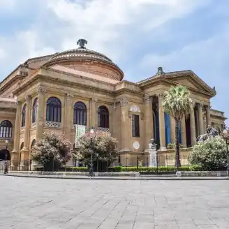 ancient building of opera house located on well groomed square against blue sky